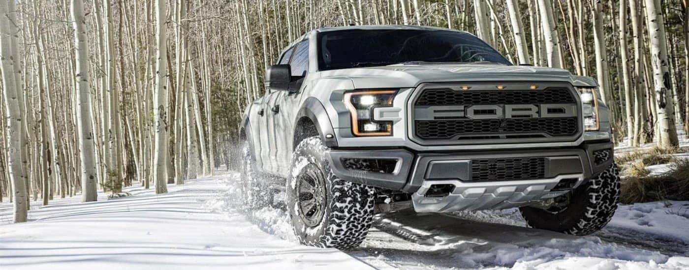 White 2017 Ford F-150 driving through the snow.