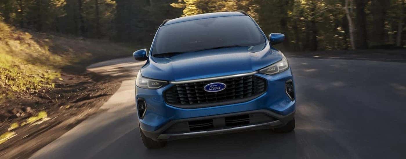 A blue 2023 Ford Escape Platinum is shown from the front driving.