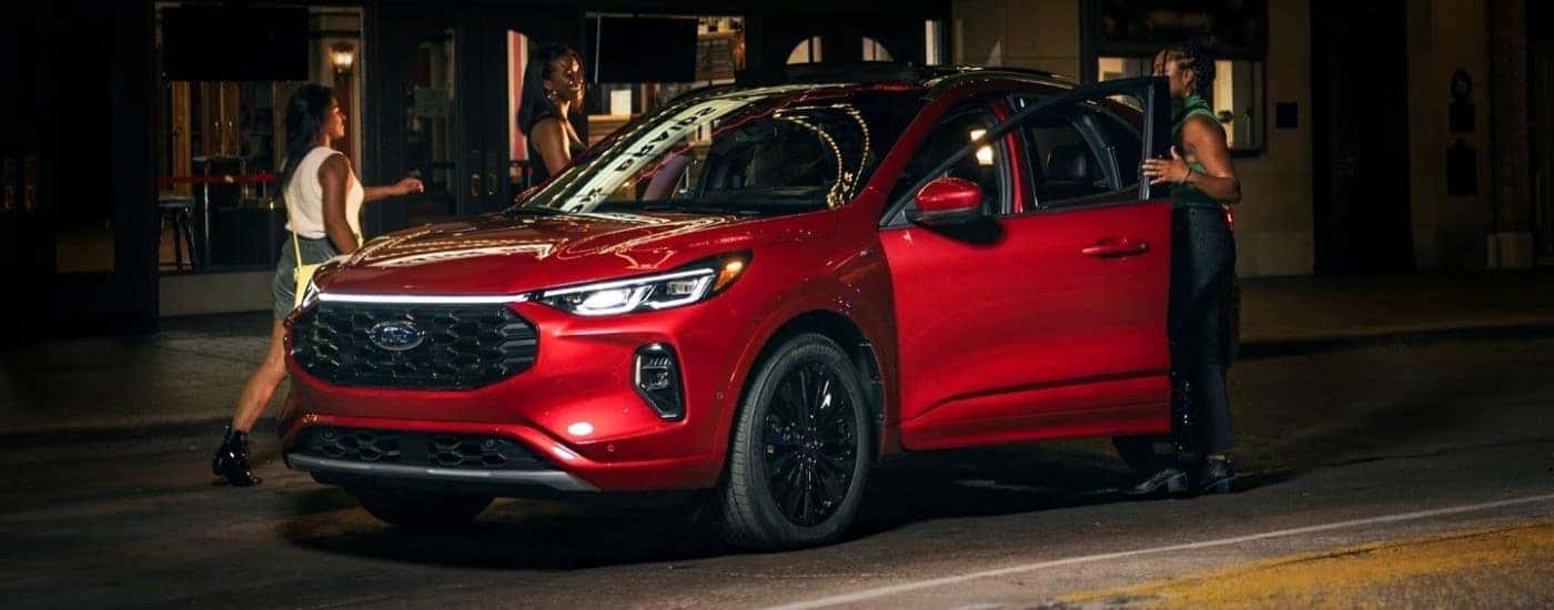 A red 2023 Ford Escape is shown parked at night.