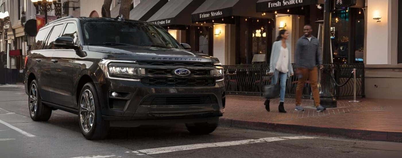 A black 2023 Ford Expedition shown parked outside a steakhouse.