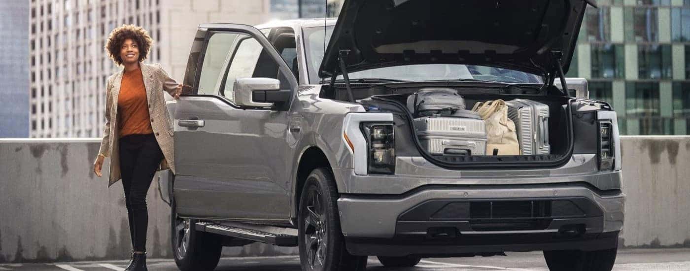 Luggage is shown in the the frunk of a silver 2023 Ford F-150 Lightning.