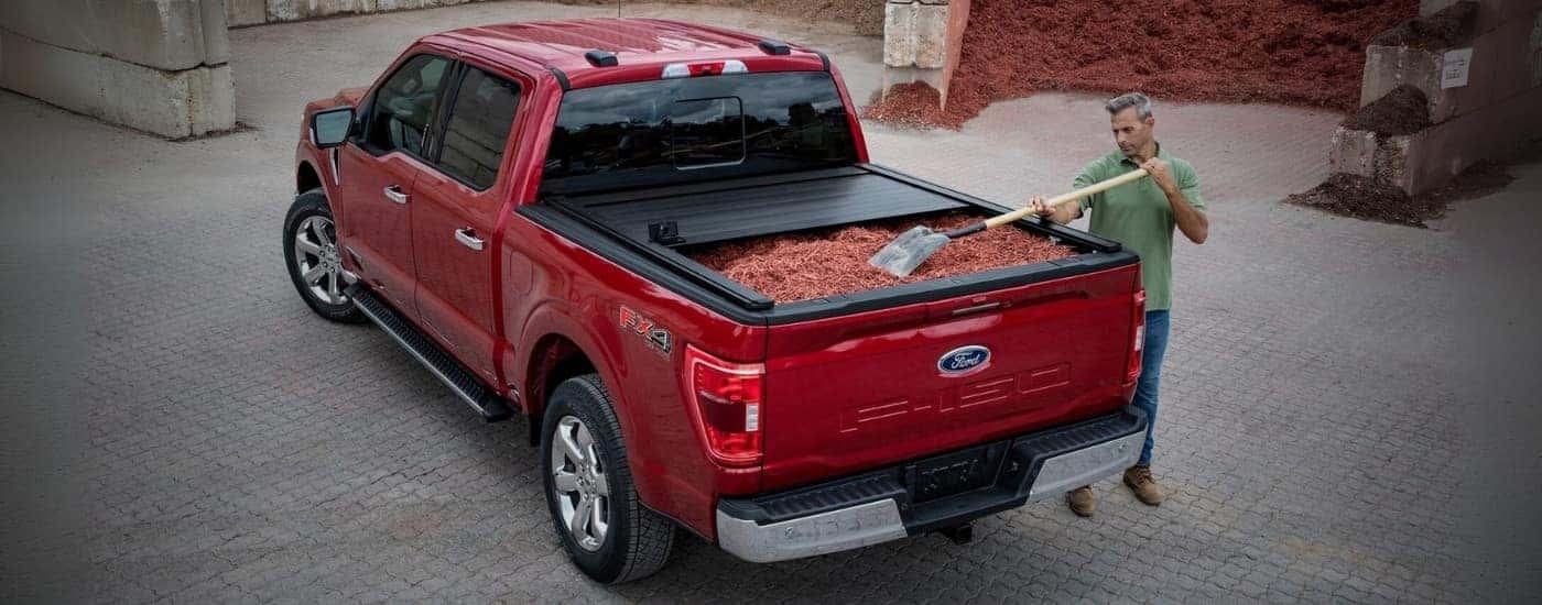 A red 2023 Ford F-150 being filled with mulch.