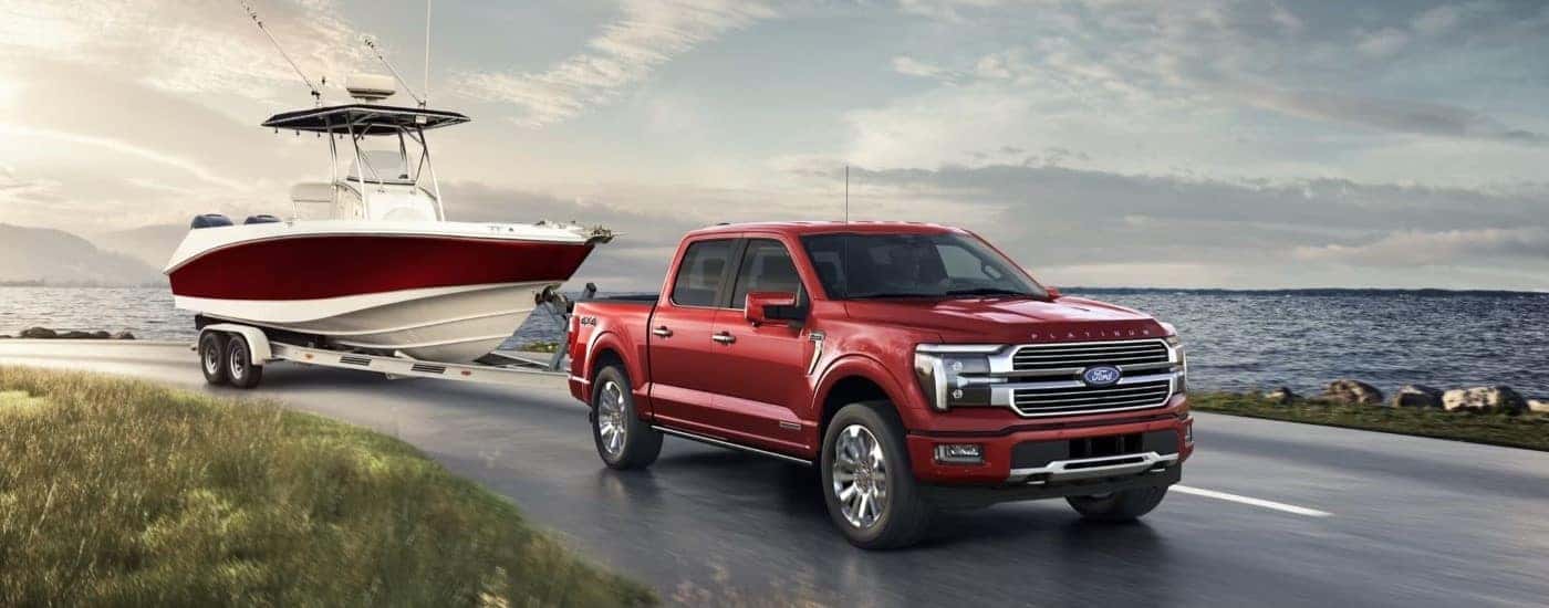 A red 2024 Ford F-150 Platinum towing a boat.