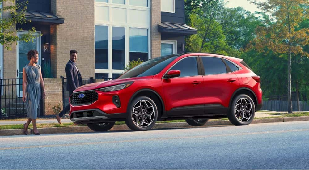 Red 2026 Ford Escape parked in front of an apartment with a couple walking to it.