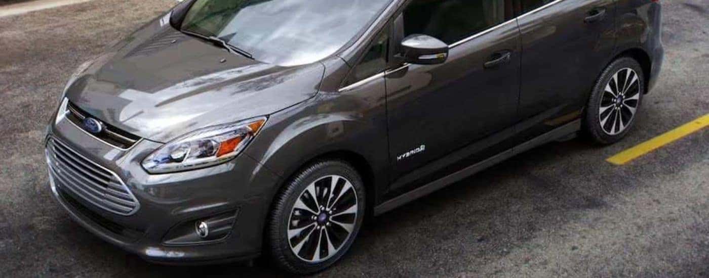 A grey 2018 Ford C-MAX is shown driving on a city street.
