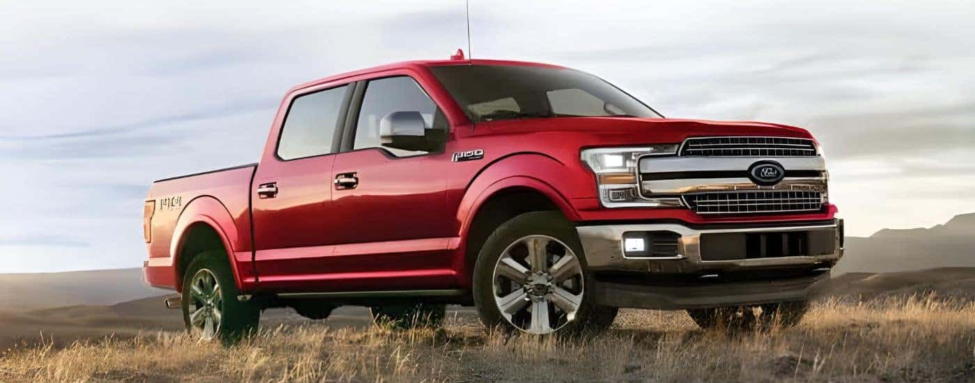 A red 2020 Ford F-150 is shown parked in a dry grassy field.