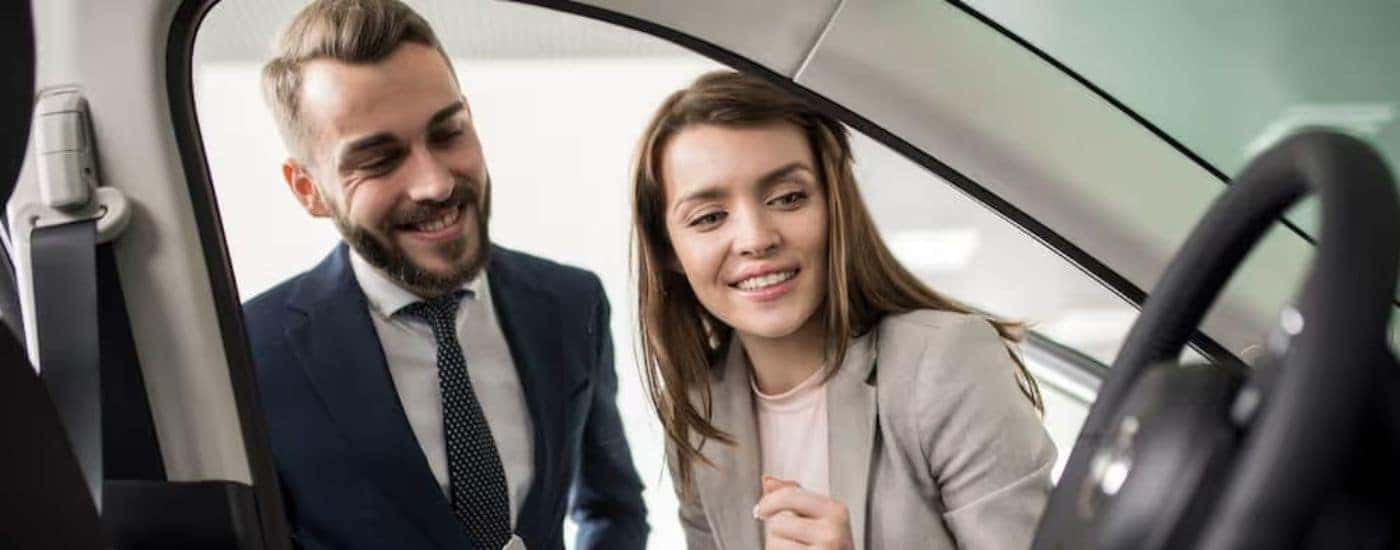 A salesperson is shown talking to someone about the value of their car.