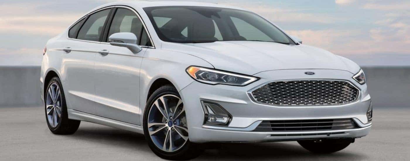 A white 2018 used Ford Fusion is parked on a parking structure.