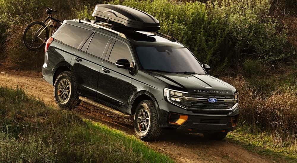 A black 2027 Ford Expedition Tremor with optional equipment shown driving a dirt path.