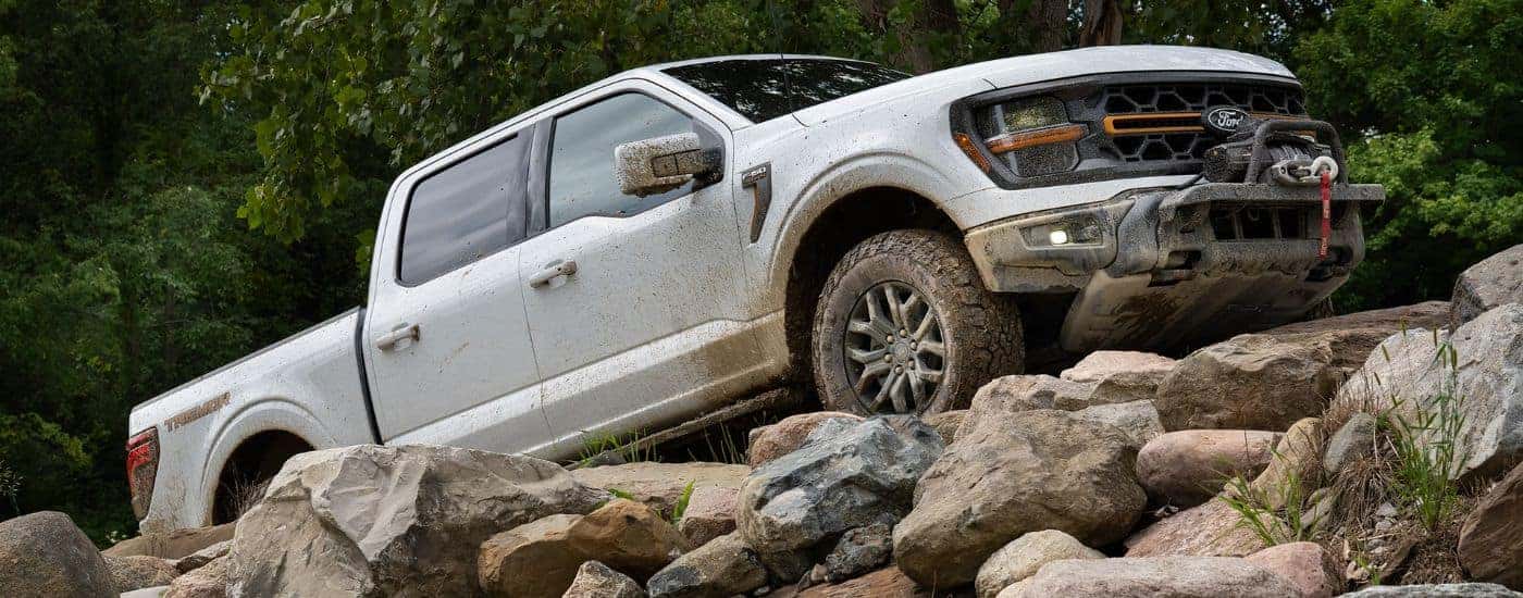 White 2026 Ford F-150 driving up rocks.