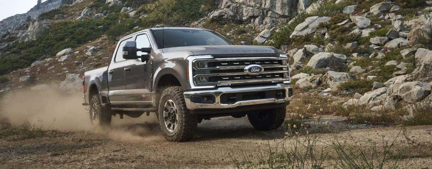 A gray 2023 Ford F-250 Tremor kicking up dust on a trail.