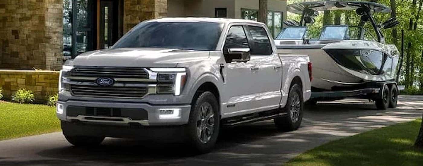 A white 2026 Ford F-150 towing a boat.