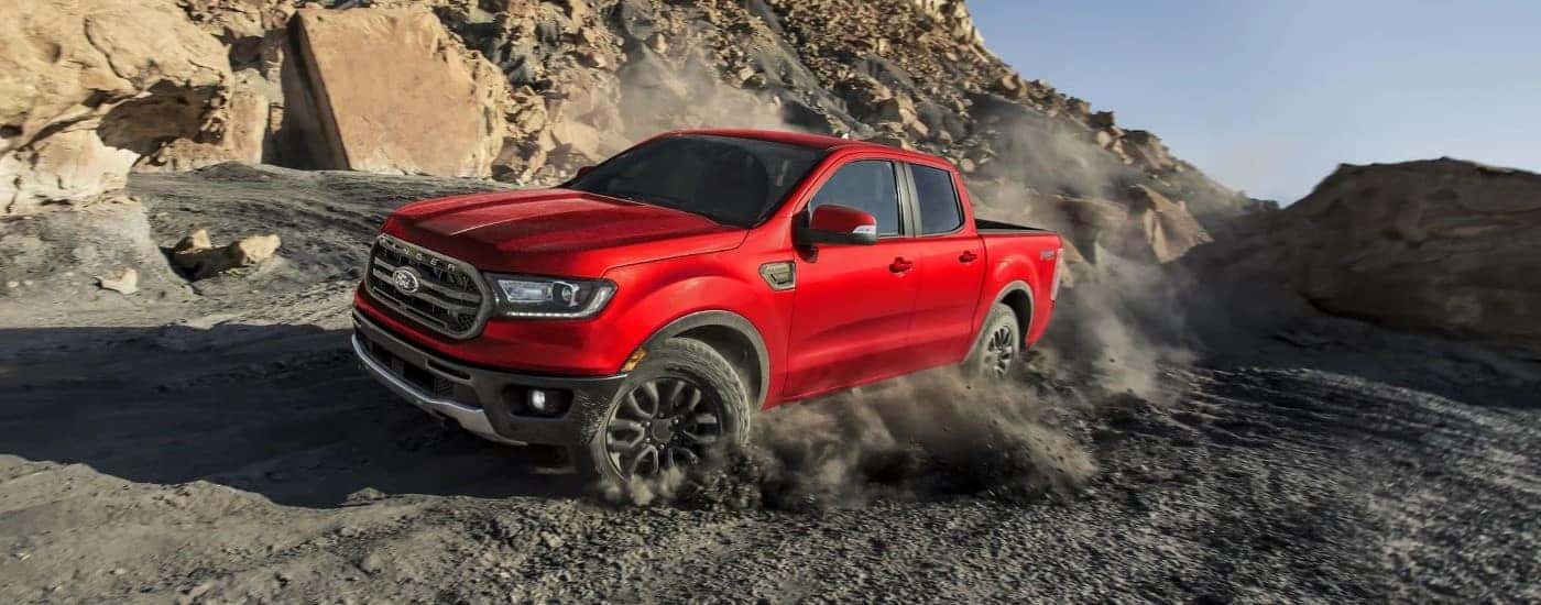A red 2023 Ford Ranger FX4 kicking up dust.