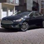 A black 2020 Ford Fusion is parked outside of a modern home after leaving the Shelbyville used Ford dealership.