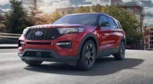 A red 2021 Ford Explorer ST is driving in a city after leaving a Ford dealer near you.