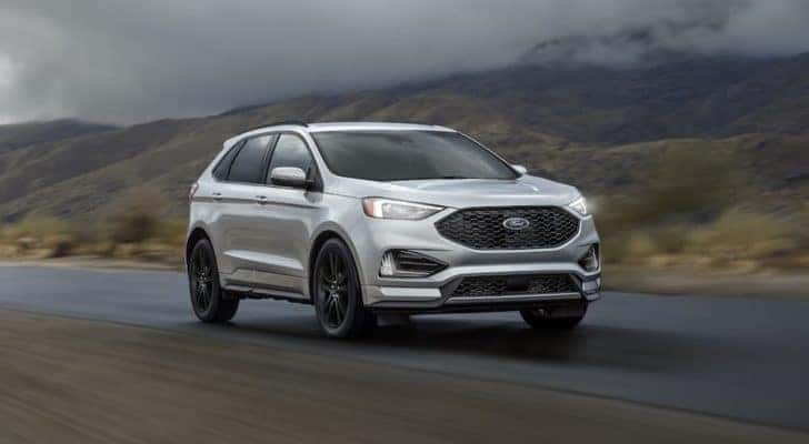 A silver 2019 Ford Edge is shown driving on an empty road after leaving a Tullahoma used Ford dealer.
