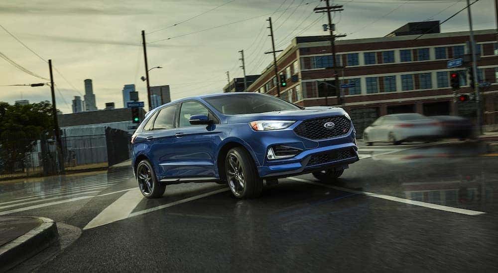 A blue 2018 Ford Edge is shown driving through an intersection after visiting a Murfreesboro used Ford dealership.
