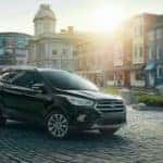 A black 2018 Ford Escape is shown in a city on a paver pathway.