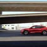A red 2022 Ford Mustang Mach-E Premium is shown from the side driving near a ramp after visiting a Murfreesboro Ford dealer.