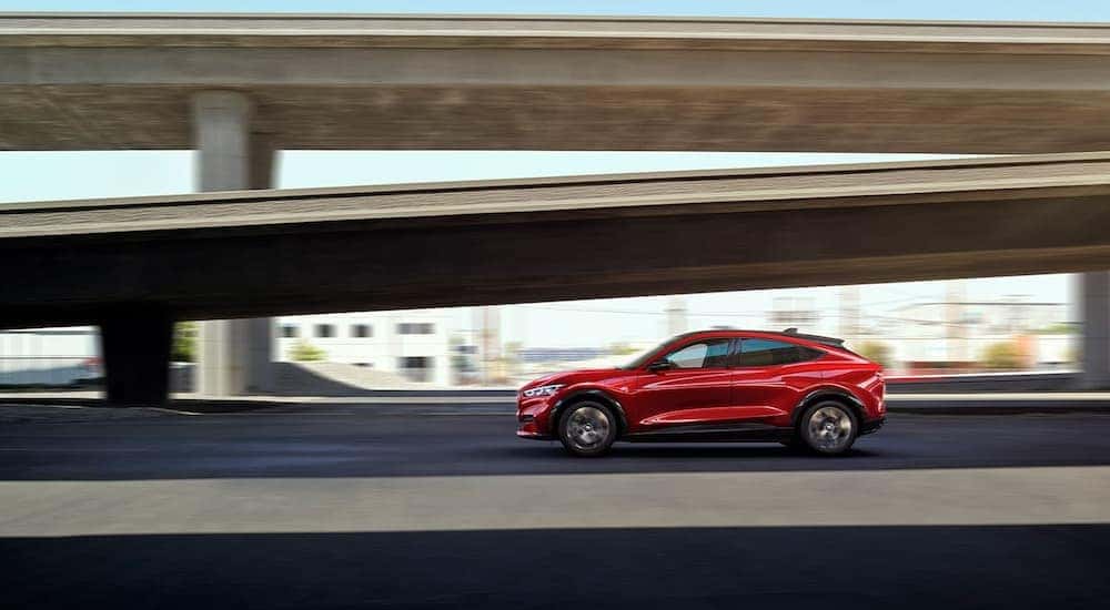 A red 2022 Ford Mustang Mach-E Premium is shown from the side driving near a ramp after visiting a Murfreesboro Ford dealer.