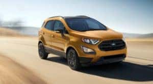 A yellow 2022 Ford EcoSport is shown driving on an open road.