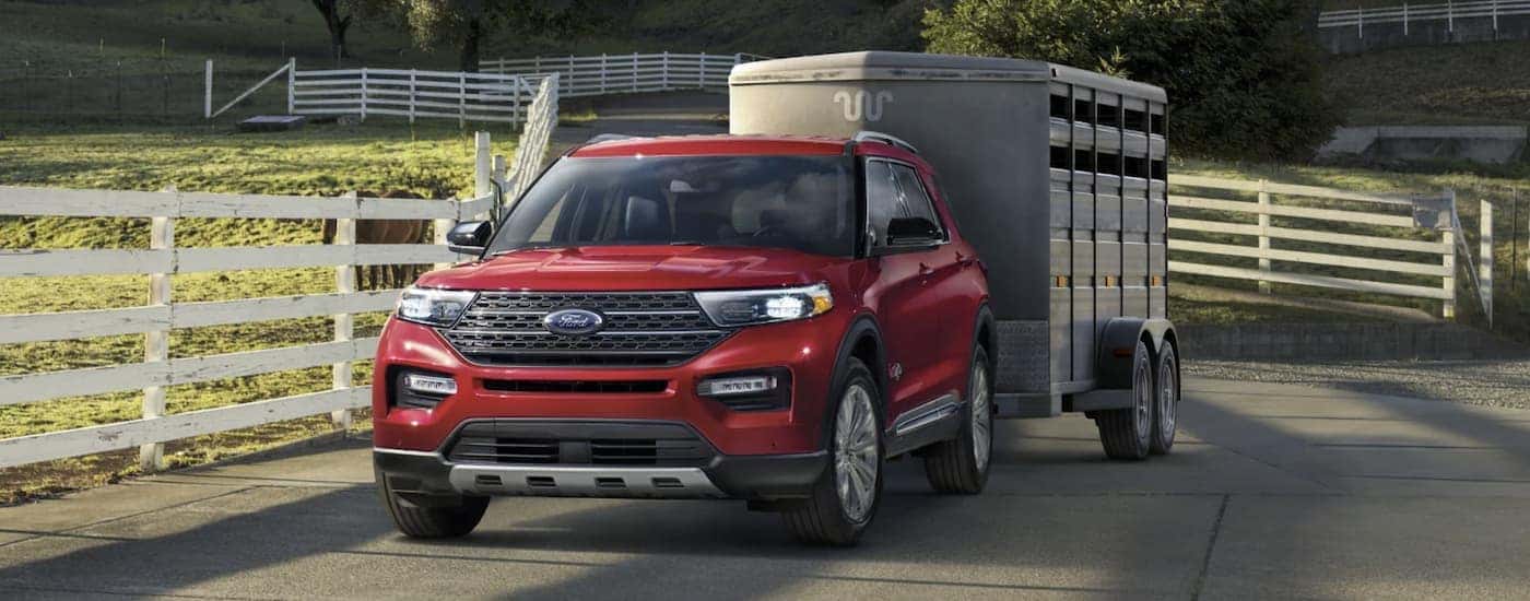 A red 2022 Ford Explorer is shown towing a trailer.