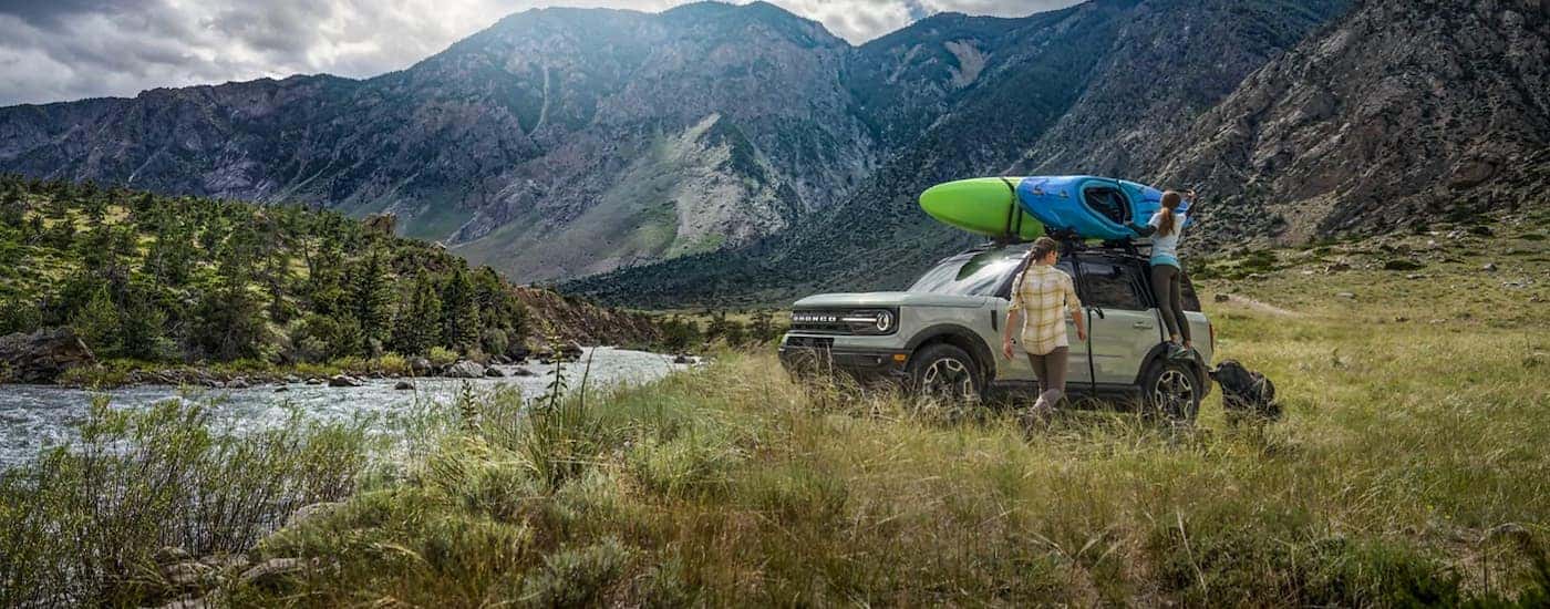 A silver 2021 Ford Bronco Sport is shown parked next to a river.