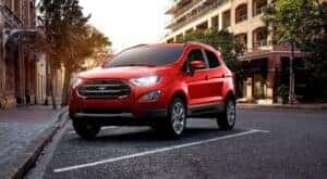 A red 2022 Ford EcoSport is shown parked on the side of a city street.