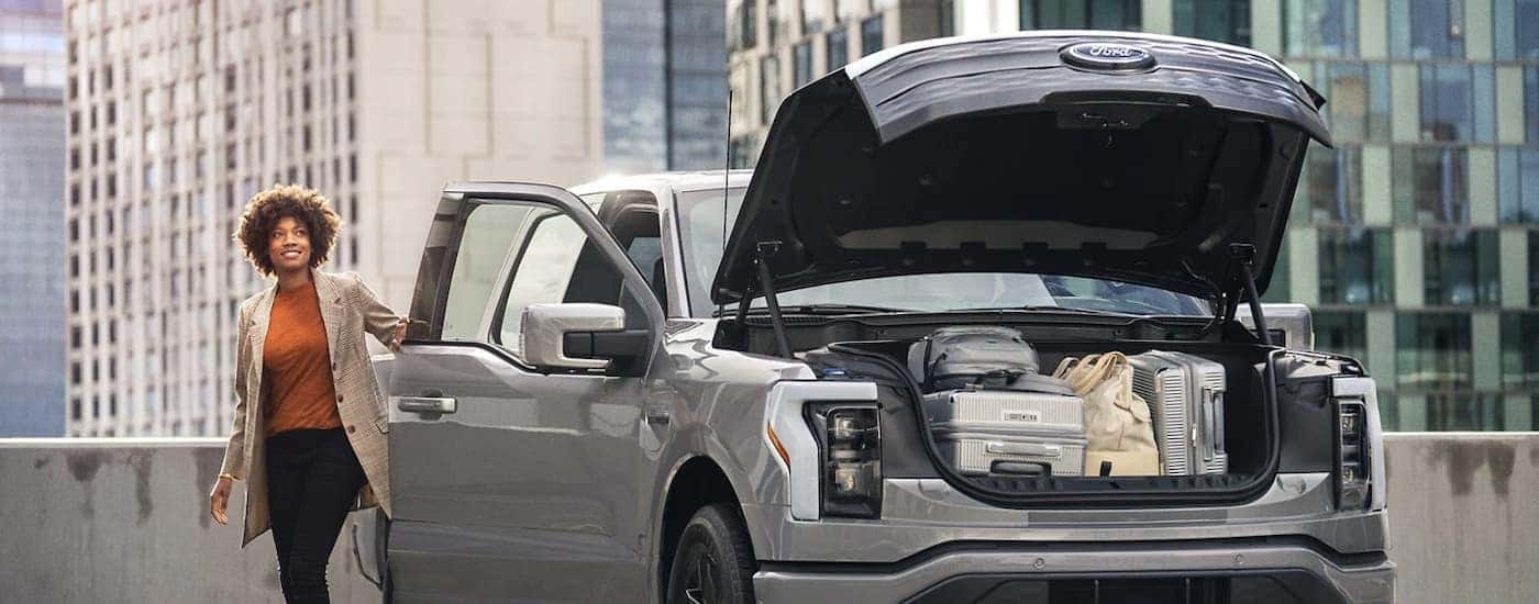 A grey 2023 Ford Lightning is shown with the frunk open and full of cargo.
