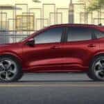 A red 2023 Ford Escape is shown from the side driving through a city.