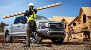 A silver 2021 Ford F-150 XLT is shown parked at a construction site.