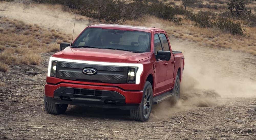 A red 2023 Ford F-150 Lightning off-roading in the desert
