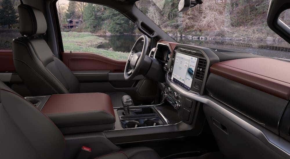 The brown interior of a 2023 Ford F-150 is shown from the passenger seat.