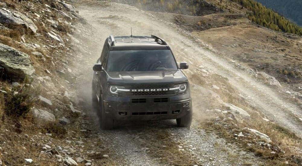 A gray 2023 Ford Bronco Sport Badlands is shown driving off-road on a rocky path.