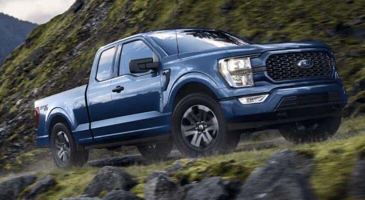 A blue 2023 Ford F-150 STX is shown from the front at an angle after leaving a dealer that has a Ford F-150 for sale in Shelbyville.