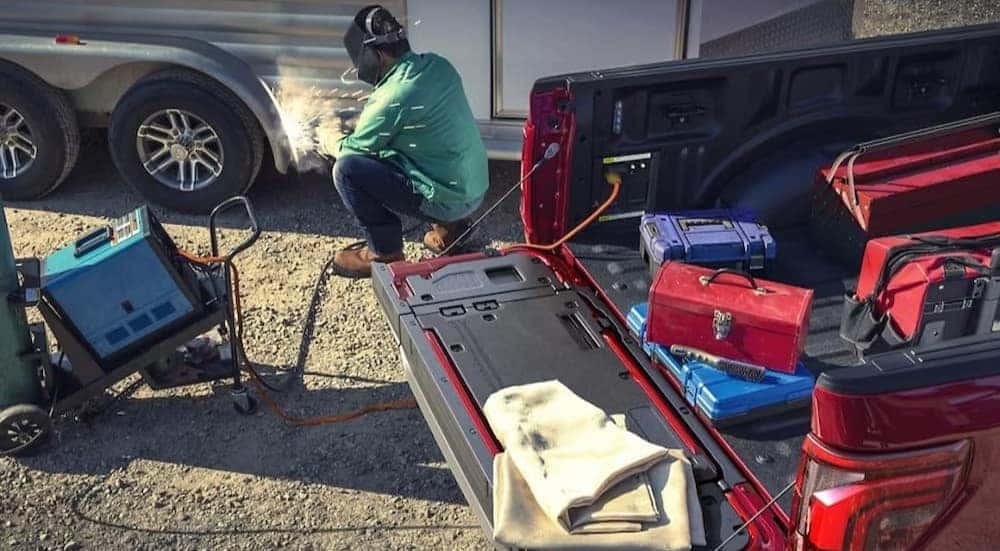 A person is shown welding near a 2024 Ford F-150 Lariat.