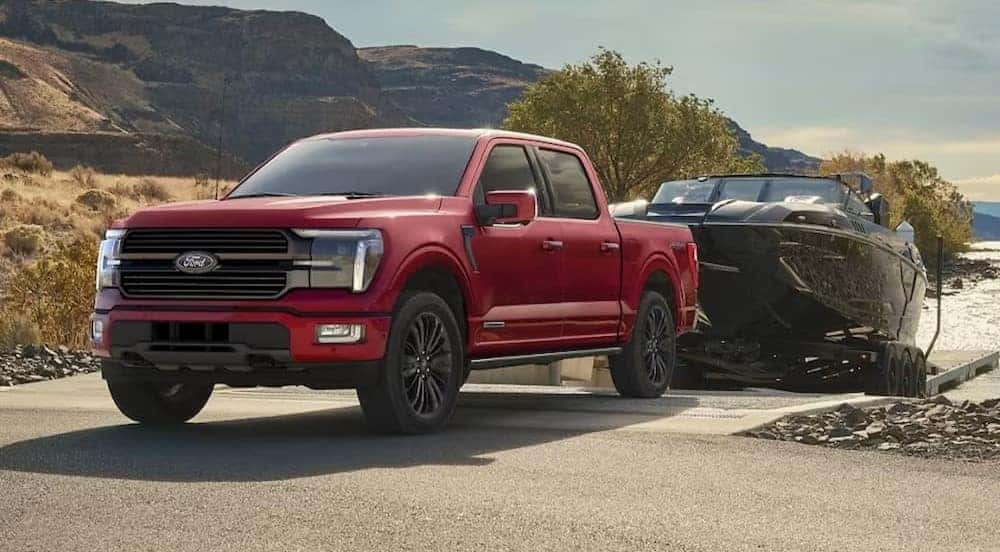 A common Ford F-150 for Sale Near Murfreesboro, a red 2024 Ford F-150, is shown towing a boat.