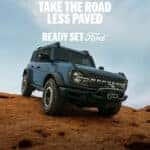 Ford Bronco driving over a hill