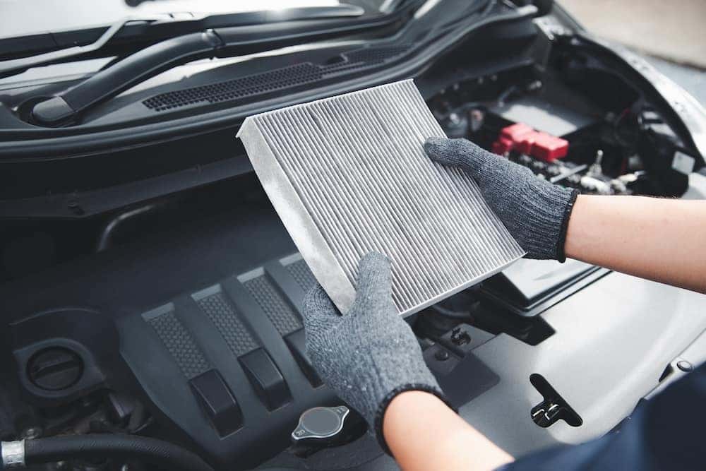 Auto mechanic holding old car air filter pollution to checking cleaning and replacing new for fix heat car air conditioner service maintenance