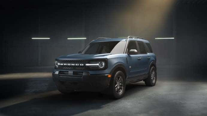 A blue Ford Bronco Sport in a large garage or warehouse.