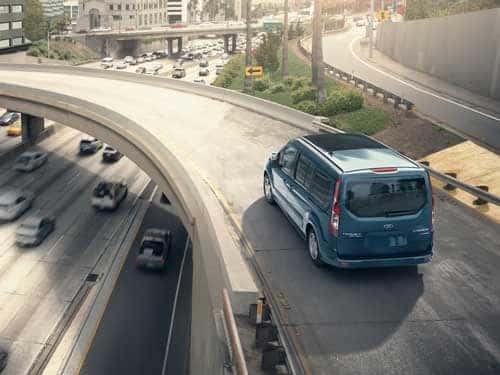 2023 Ford Transit Connect driving down an interstate ramp