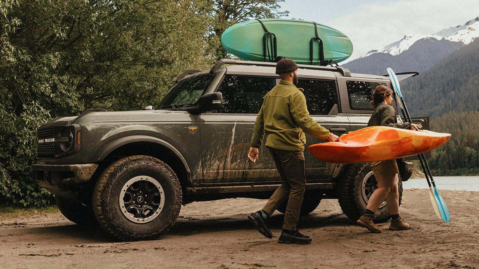 People Carrying Kayak Next to 2026 Ford Bronco