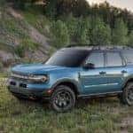 A blue 2021 Ford Bronco Sport is shown from the side parked in front of a hill.