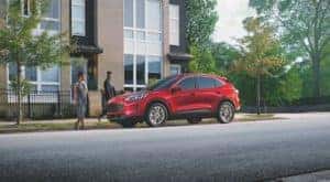 A red 2020 Ford Escape SE is shown parked outside of a modern building after leaving a Certified Pre-Owned Ford Escape dealer.