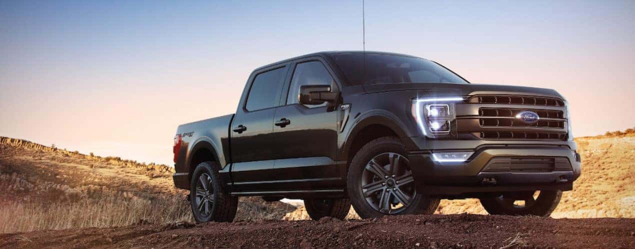 A black 2022 Ford F-150 Lariat is shown parked on top of a dirt mound.