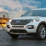 White 2021 Ford Explorer parked on a boardwalk with a ferris wheel in the background