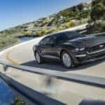 A 2023 Ford Mustang driving around a curve